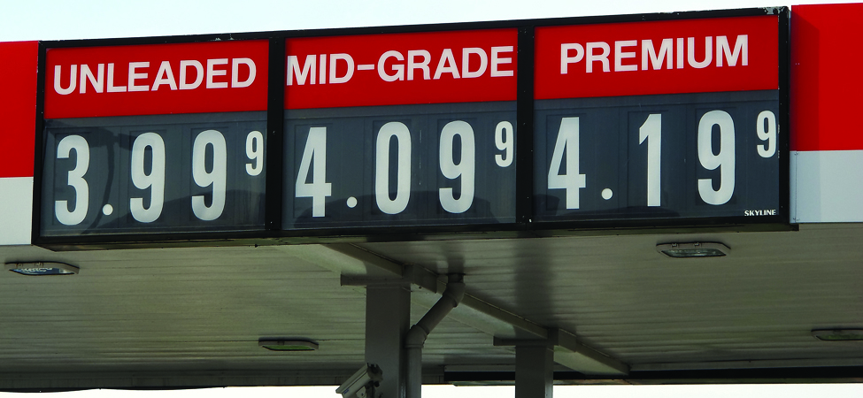 A gas station sign is shown. It lists unleaded as 3.999, mid-grade as 4.099, and premium as 4.199.